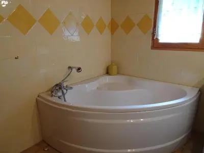 a large white tub in a bathroom with a window at Chalet des Glaciers in Chamonix-Mont-Blanc
