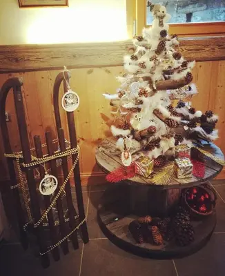 a christmas tree in a room with a table and chairs at Chantemerle 1741, chambres d'hôtes à la montagne in Sallanches
