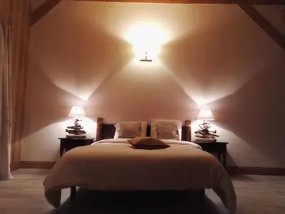a bedroom with a bed with two lights on the wall at Chantemerle 1741, chambres d'hôtes à la montagne in Sallanches