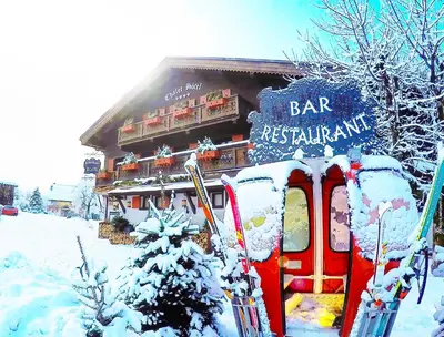 a bird standing next to a basket of wine bottles at Hotel Le Castel in Chamonix-Mont-Blanc