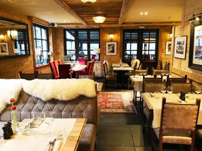 a restaurant with tables and chairs in a room at Hotel Le Castel in Chamonix-Mont-Blanc