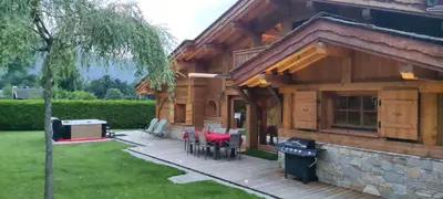 a house with a deck with tables and chairs at Chalet KIDOU, Grand Confort, nouveau SPA extérieur in Chamonix-Mont-Blanc
