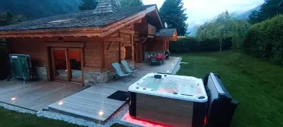 a log cabin with a hot tub on a deck at Chalet KIDOU, Grand Confort, nouveau SPA extérieur in Chamonix-Mont-Blanc