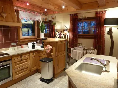 a large kitchen with a sink and a table at Chalet KIDOU, Grand Confort, nouveau SPA extérieur in Chamonix-Mont-Blanc