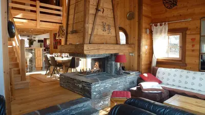 a living room with a fireplace in a cabin at Chalet KIDOU, Grand Confort, nouveau SPA extérieur in Chamonix-Mont-Blanc