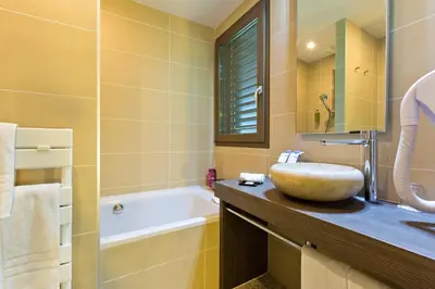 a bathroom with a sink and a bath tub at La Croix de Savoie & Spa in Les Carroz d'Araches