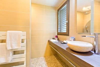 a bathroom with a sink and a mirror at La Croix de Savoie & Spa in Les Carroz d'Araches