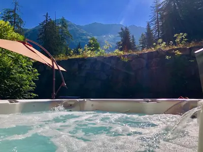 a hot tub with water and an umbrella at Chalet Hideaway 2 in Chamonix-Mont-Blanc