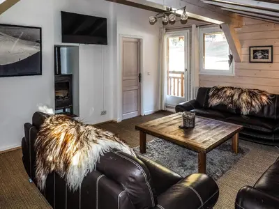 a living room with leather furniture and a table at Chalet Hideaway 2 in Chamonix-Mont-Blanc