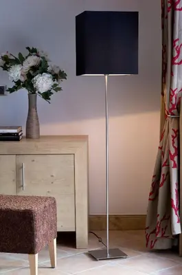 a lamp in a room with a table and a vase of flowers at CGH Résidence Boutique Les Chalets de Léana in Les Carroz d'Araches