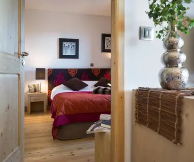 a bedroom with a bed and a vase at CGH Résidence Boutique Les Chalets de Léana in Les Carroz d'Araches