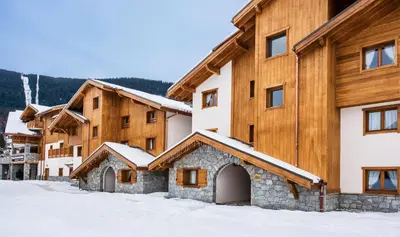 a group of buildings in the snow at CGH Résidence Boutique Les Chalets de Léana in Les Carroz d'Araches