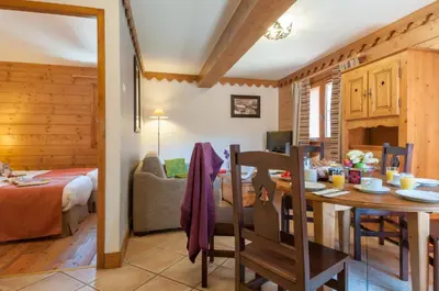 a dining room and living room in a log cabin at Residence Les Fermes du Soleil - maeva Home in Les Carroz d'Araches