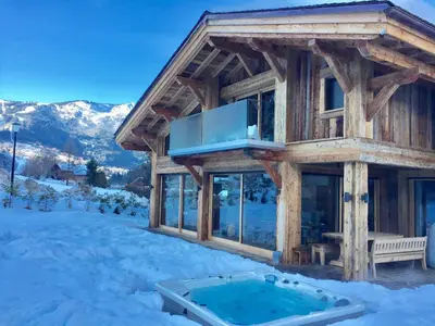 a log cabin with a hot tub in the snow at Chalet Alexandra in Les Houches