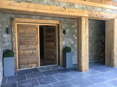 two wooden doors in a stone building with two plants at Chalet Alexandra in Les Houches