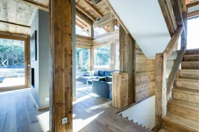 a living room with wooden walls and wooden stairs at Chalet Alexandra in Les Houches