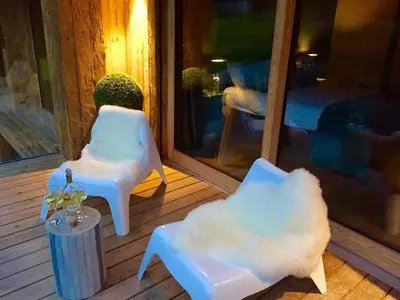 two white chairs and a table on a porch at Chalet Alexandra in Les Houches