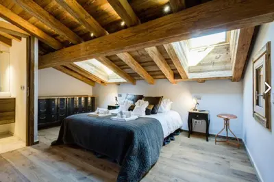 a bedroom with a bed in a room with wooden ceilings at Chalet Alexandra in Les Houches