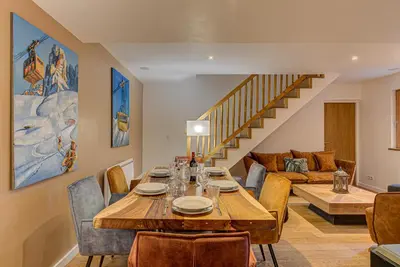 a dining room with a table and chairs and a couch at APARTMENT BIOLAY - Alpes Travel - Central Chamonix - Sleeps 6 in Chamonix-Mont-Blanc
