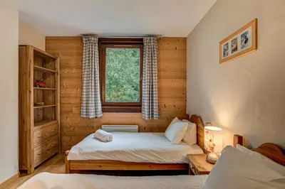 a bedroom with two beds and a window at APARTMENT STADDON - Alpes Travel - Central Chamonix - Sleeps 4-6 in Chamonix-Mont-Blanc