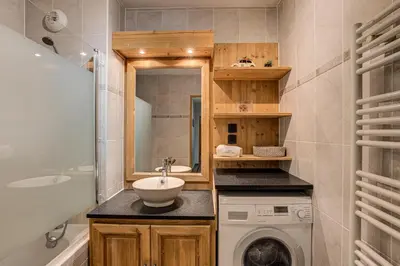 a bathroom with a sink and a washing machine at APARTMENT STADDON - Alpes Travel - Central Chamonix - Sleeps 4-6 in Chamonix-Mont-Blanc