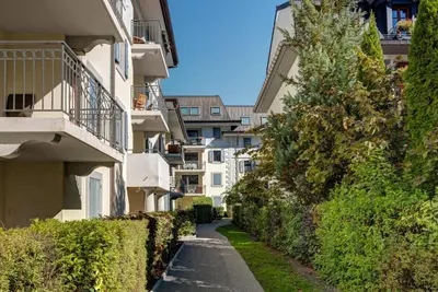 an alley between two buildings with bushes at APARTMENT STADDON - Alpes Travel - Central Chamonix - Sleeps 4-6 in Chamonix-Mont-Blanc