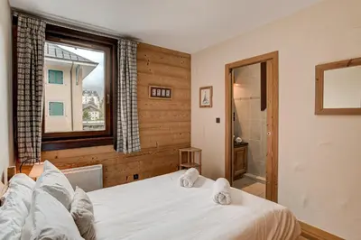 a bedroom with a white bed and a window at APARTMENT STADDON - Alpes Travel - Central Chamonix - Sleeps 4-6 in Chamonix-Mont-Blanc