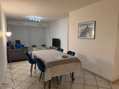 a room with a table and a living room at Appartement CITY CENTER-SALLANCHES in Sallanches
