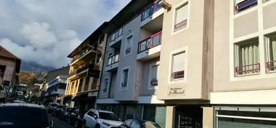 a city street with cars parked in front of buildings at Appartement CITY CENTER-SALLANCHES in Sallanches