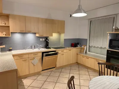 a kitchen with wooden cabinets and a sink at Appartement CITY CENTER-SALLANCHES in Sallanches