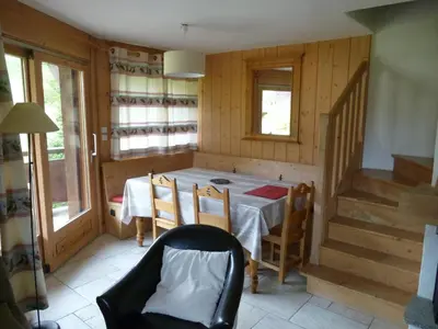 a dining room with a table and chairs and stairs at Chalets de Julie in Megève
