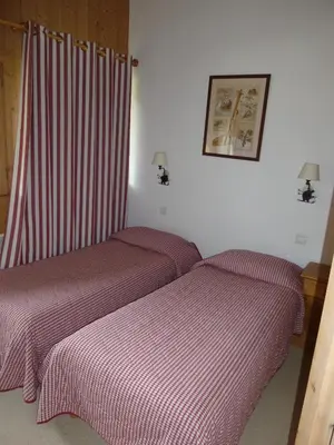 two beds in a room with red and white sheets at Chalets de Julie in Megève