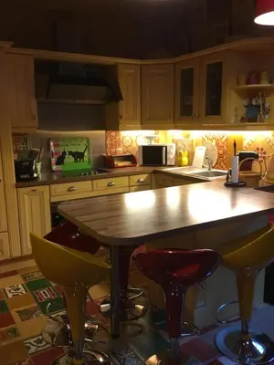 a kitchen with a wooden table and some stools at chalet des petits loups in Chamonix-Mont-Blanc