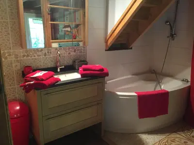 a bathroom with a tub and a sink and red towels at chalet des petits loups in Chamonix-Mont-Blanc