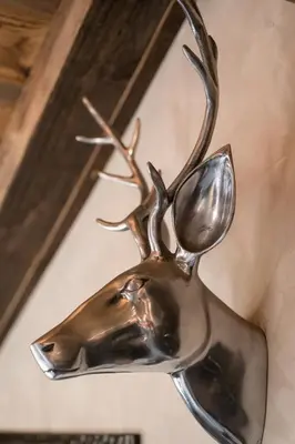 a metal reindeer ornament hanging on a wall at Le Cocoon de Sarah in Chamonix-Mont-Blanc