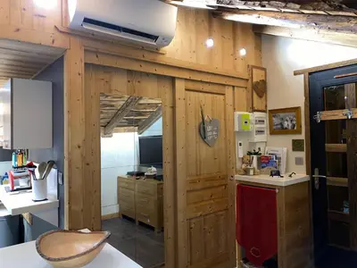 a kitchen with a wooden wall with a tv on it at Le Cocoon de Sarah in Chamonix-Mont-Blanc