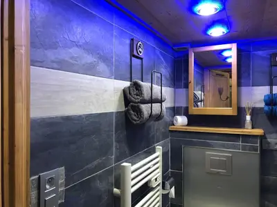 a bathroom with a blue wall and a mirror at Le Cocoon de Sarah in Chamonix-Mont-Blanc