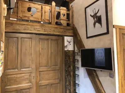 a living room with a tv and a wooden door at Le Cocoon de Sarah in Chamonix-Mont-Blanc