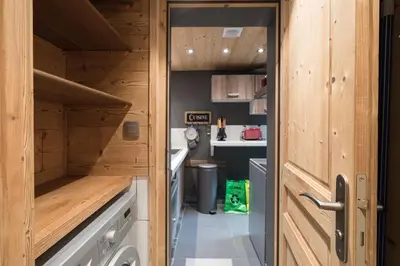 a small kitchen with wooden cabinets and a door at Le Cocoon de Sarah in Chamonix-Mont-Blanc