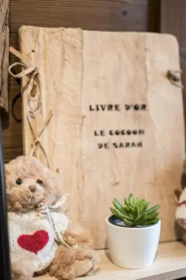 a teddy bear sitting on a shelf next to a sign at Le Cocoon de Sarah in Chamonix-Mont-Blanc