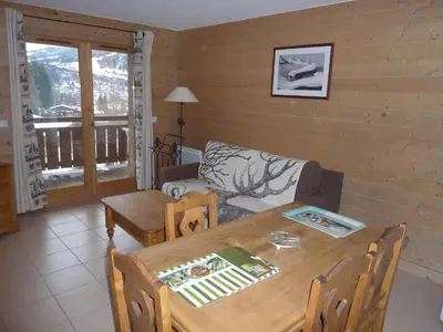 a living room with a table and a couch at Le Hameau des Neiges in Demi-Quartier