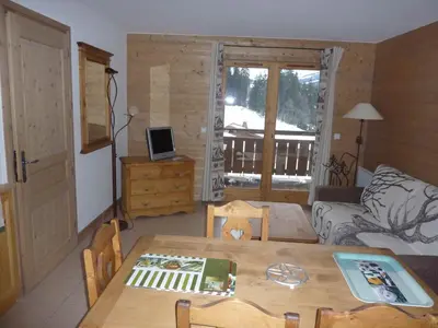 a living room with a table and a couch at Le Hameau des Neiges in Demi-Quartier
