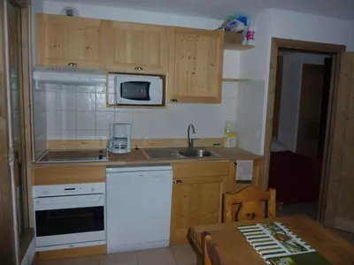 a small kitchen with a sink and a microwave at Le Hameau des Neiges in Demi-Quartier