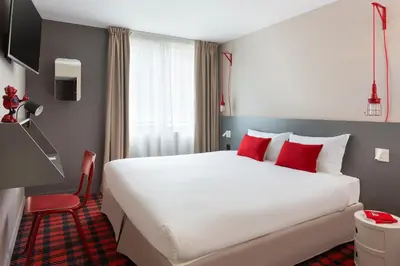 a hotel room with a large bed and a red chair at RockyPop Chamonix - Les Houches in Les Houches