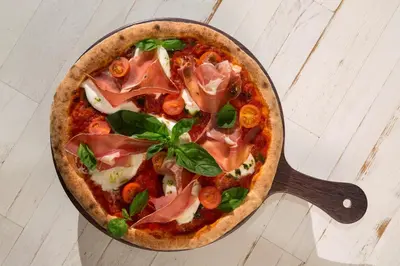 a pizza in a pan on a table at RockyPop Chamonix - Les Houches in Les Houches