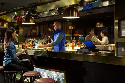 a bartender standing at a bar with a woman at RockyPop Chamonix - Les Houches in Les Houches