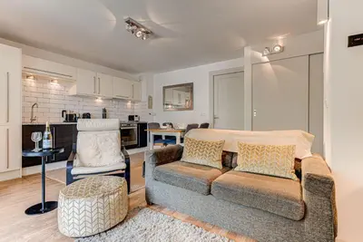 a living room with a couch and a kitchen at APARTMENT COSMIQUES - Alpes Travel - Central Chamonix - Sleeps 4 in Chamonix-Mont-Blanc
