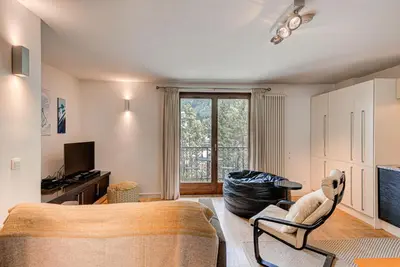 a living room with a couch and a chair at APARTMENT COSMIQUES - Alpes Travel - Central Chamonix - Sleeps 4 in Chamonix-Mont-Blanc