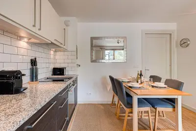 a kitchen with a table and chairs in a kitchen at APARTMENT COSMIQUES - Alpes Travel - Central Chamonix - Sleeps 4 in Chamonix-Mont-Blanc