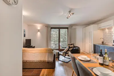 a living room with a bed and a dining room table at APARTMENT COSMIQUES - Alpes Travel - Central Chamonix - Sleeps 4 in Chamonix-Mont-Blanc